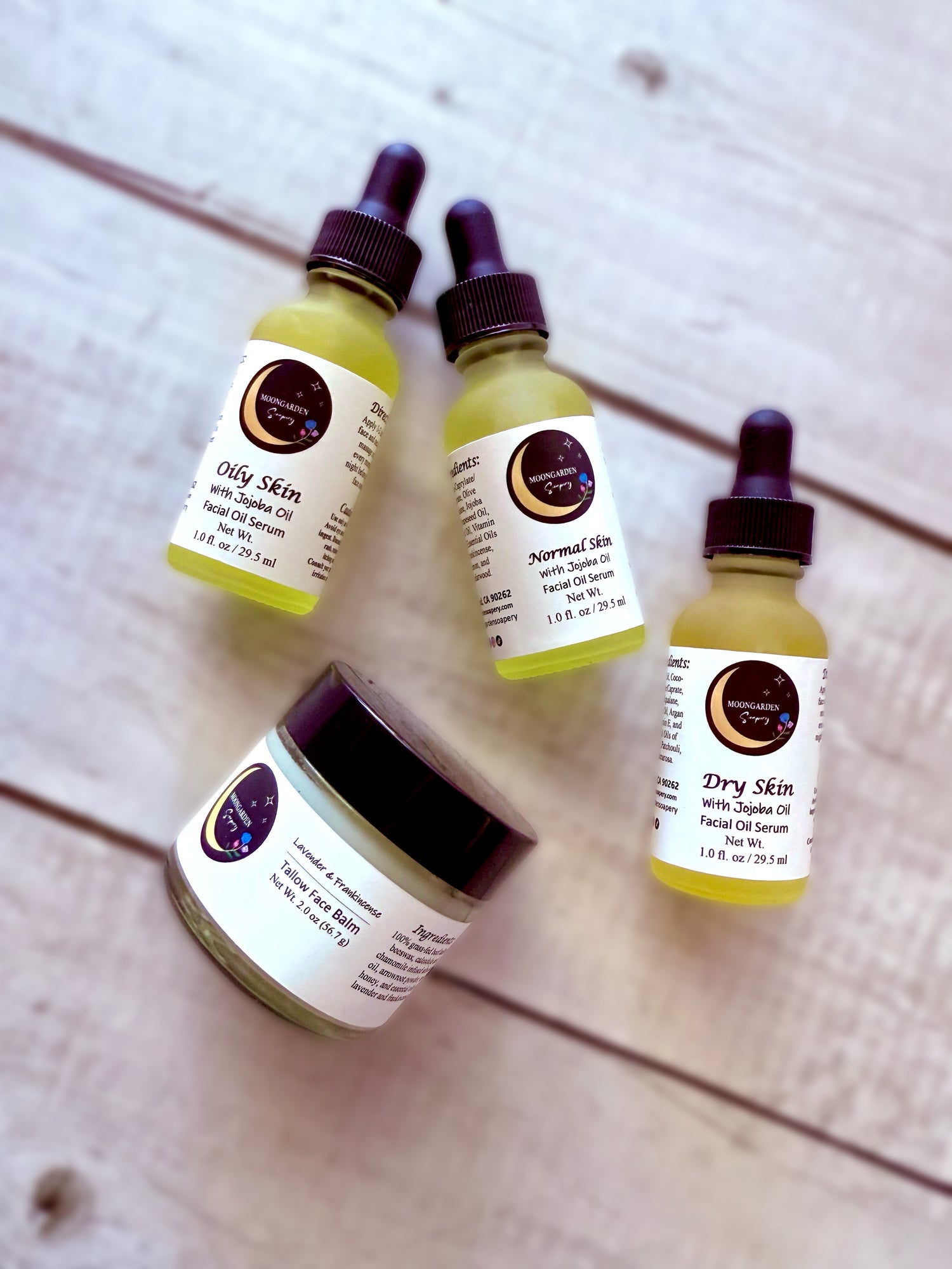 Three small bottles of facial oils and one jar of tallow balm.