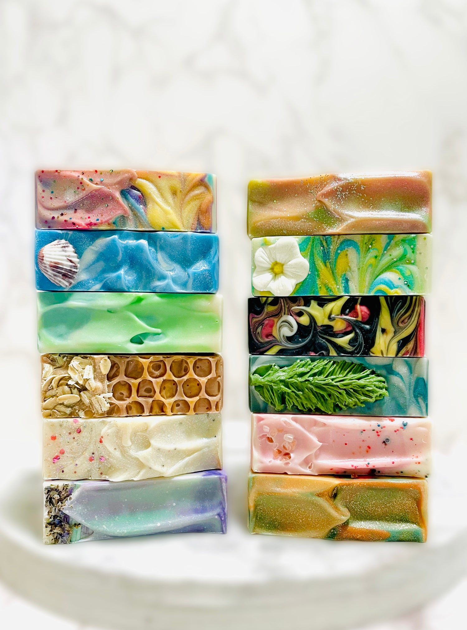 12 bar soaps stacked on top of each other on a round wooden serving tray.