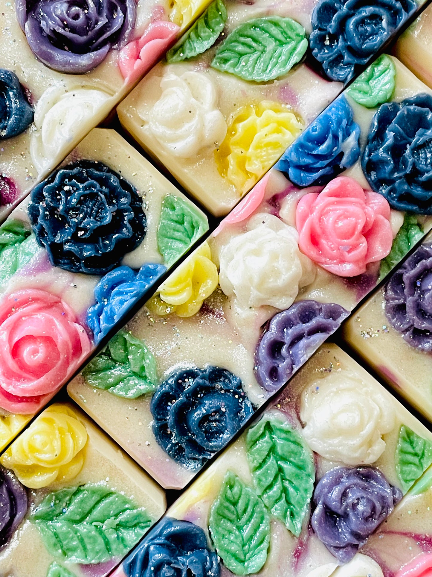 A closeup of the tops of Mrs. Oleson bar soaps. All soaps have flower soap dough embeds on top.