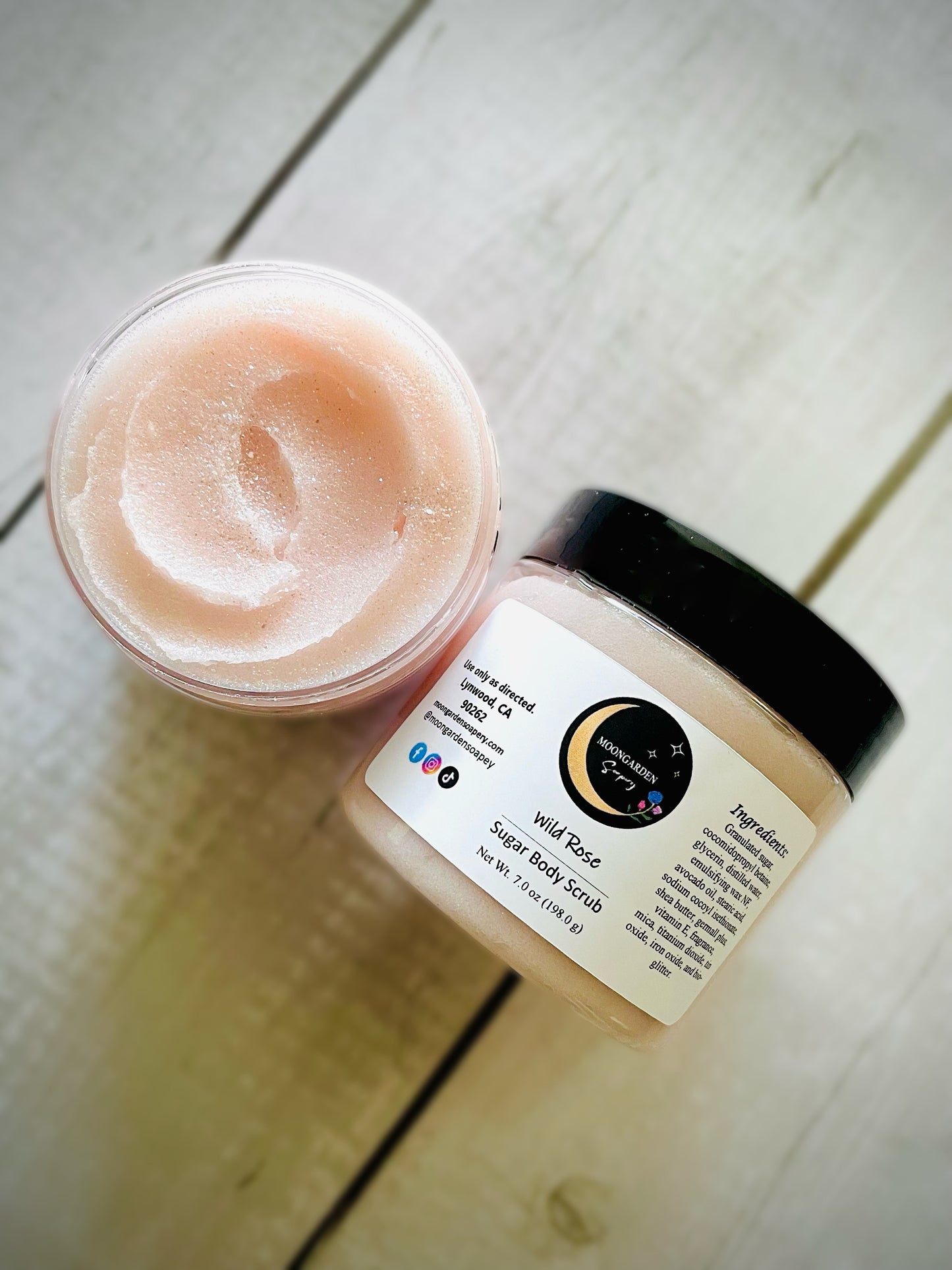 Two jars of wild rose sugar scrubs.