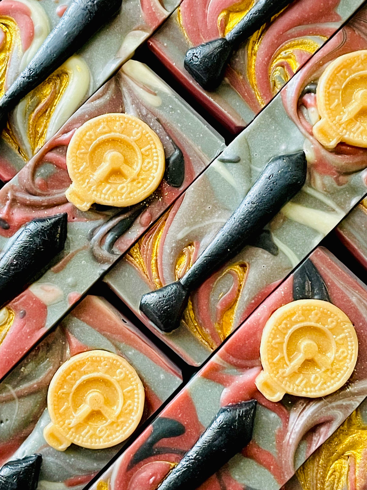 The tops of Tommy Shelby bar soaps. Each soap has a tie and pocket watch soap dough embed.