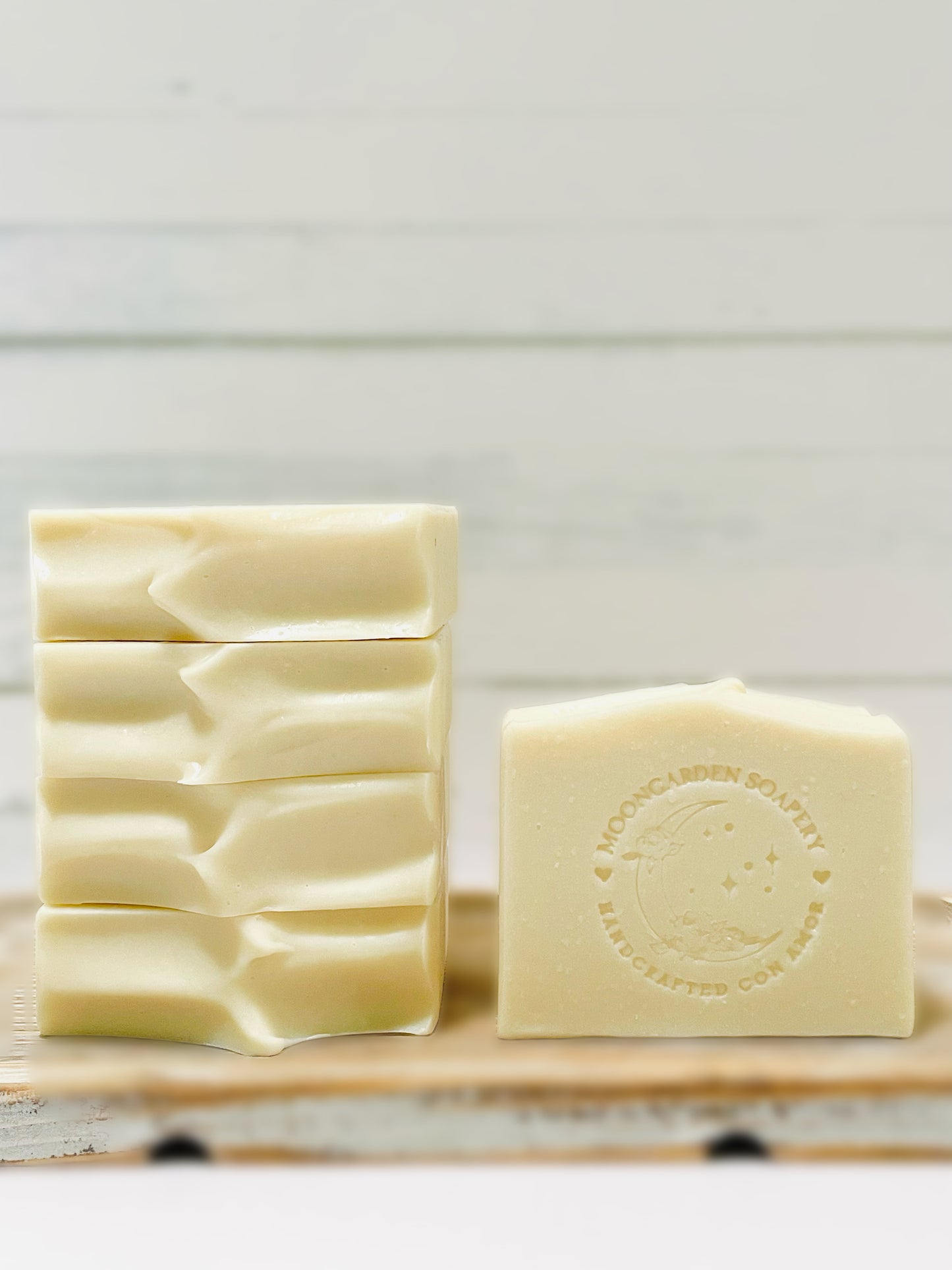 Four Ordinary soaps stacked on the left and one on the right. All soaps sit on top of a wooden serving tray.