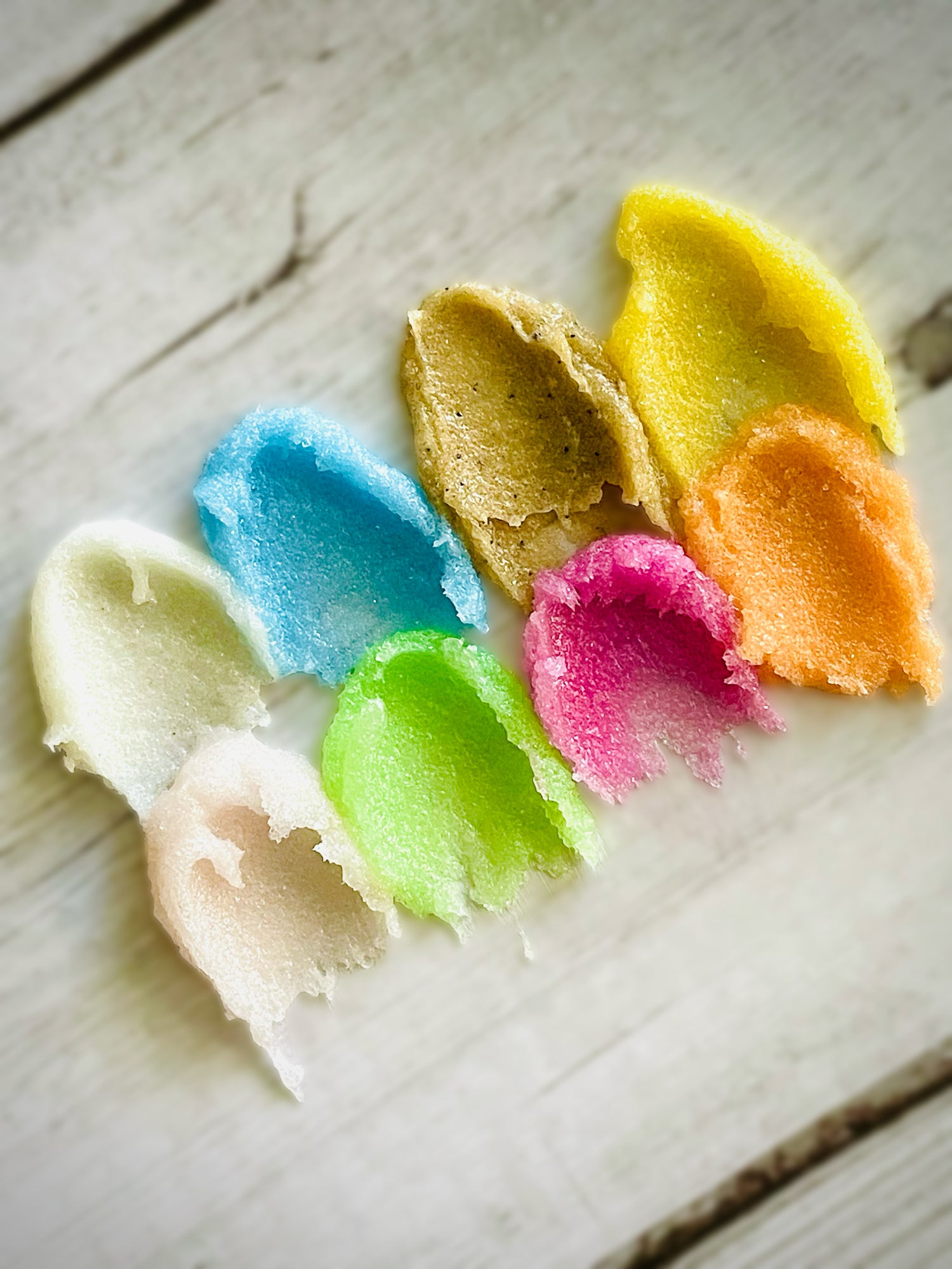 Various sugar scrub textures on a wooden background.