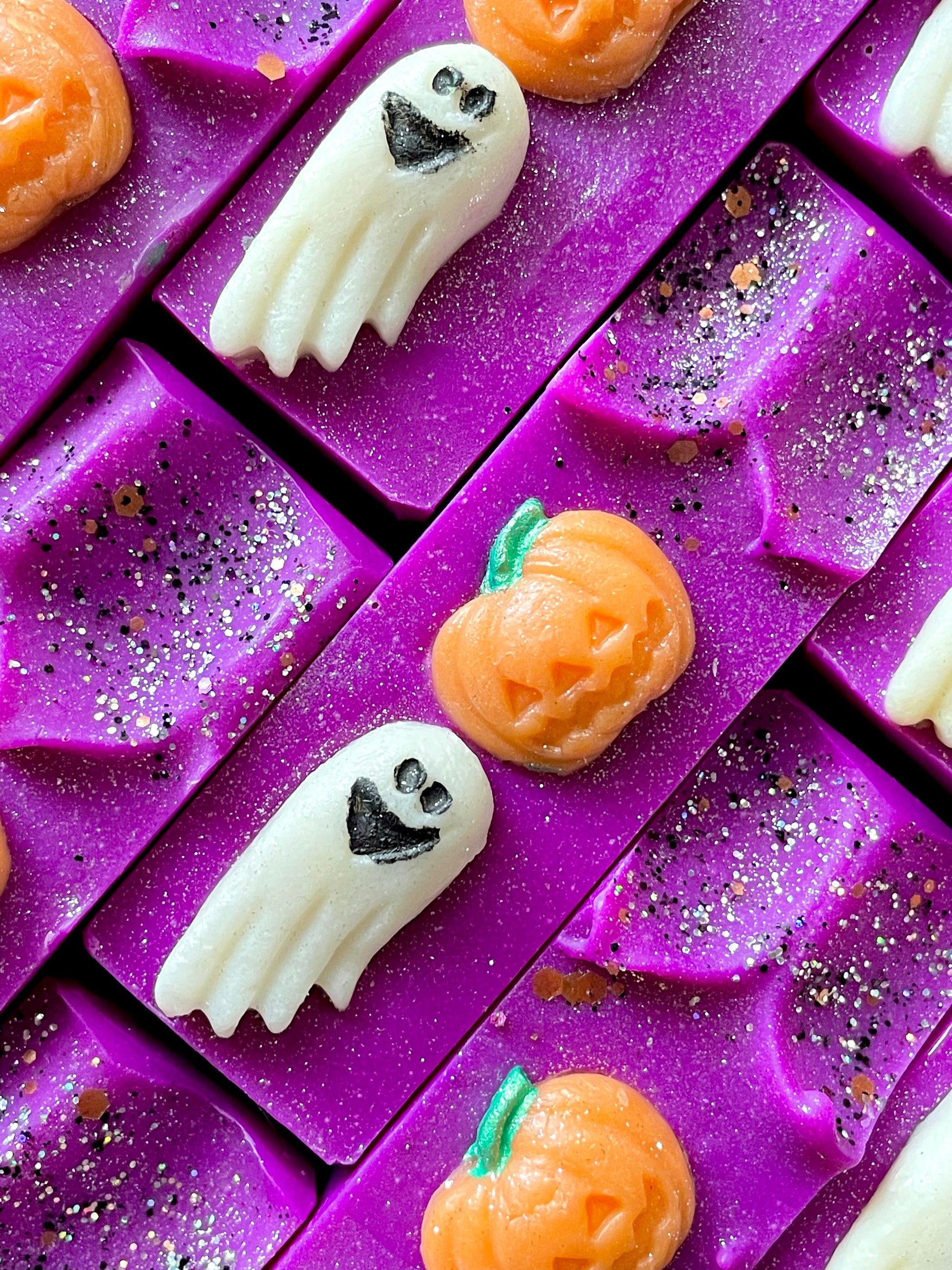 The tops of All Hallows' Eve bar soaps. Each soap has a pumpkin and ghost soap dough embed.  