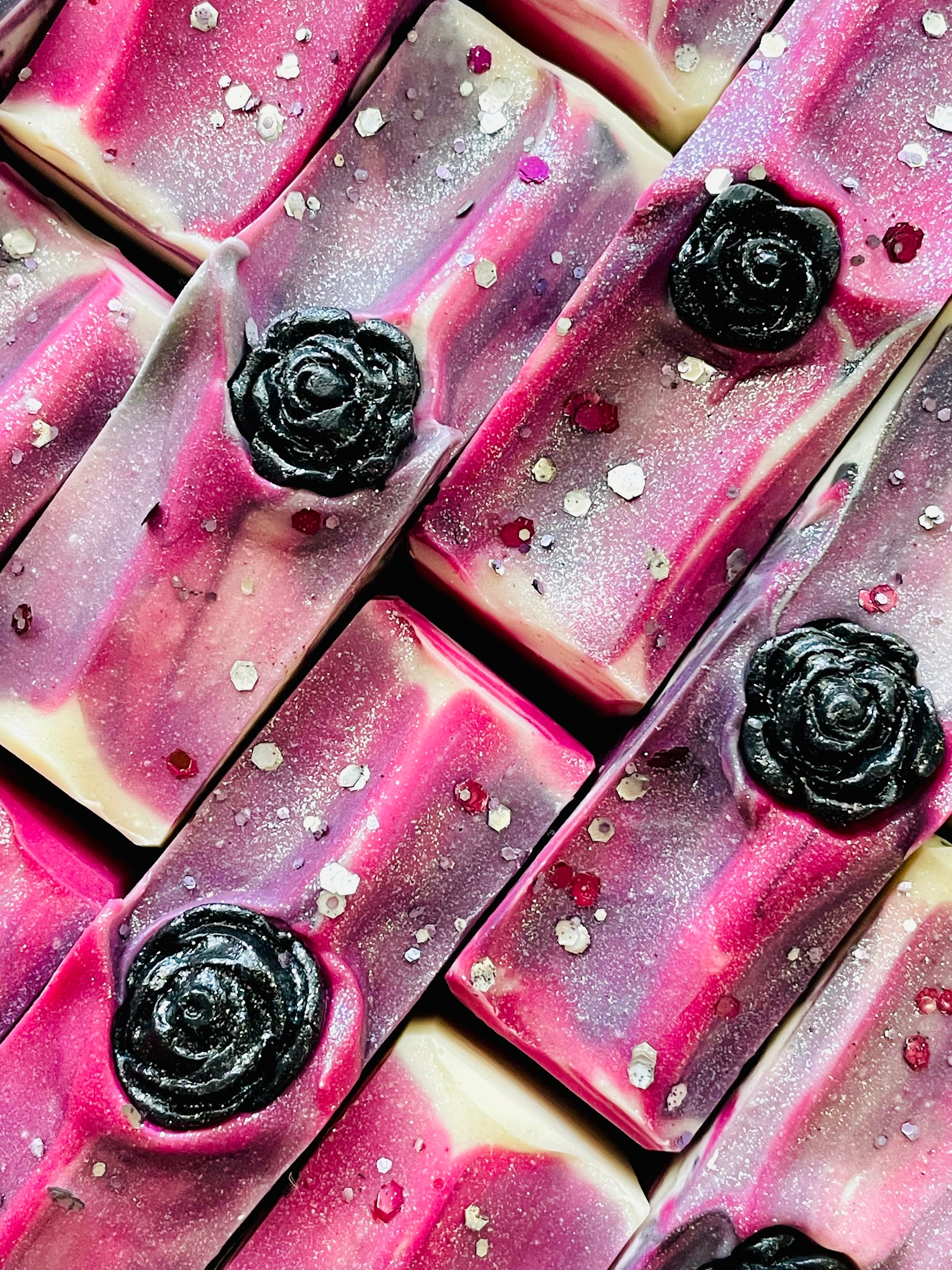 The tops of The Sweetest Perfection bar soaps. each soap has a rose soap dough embed. 