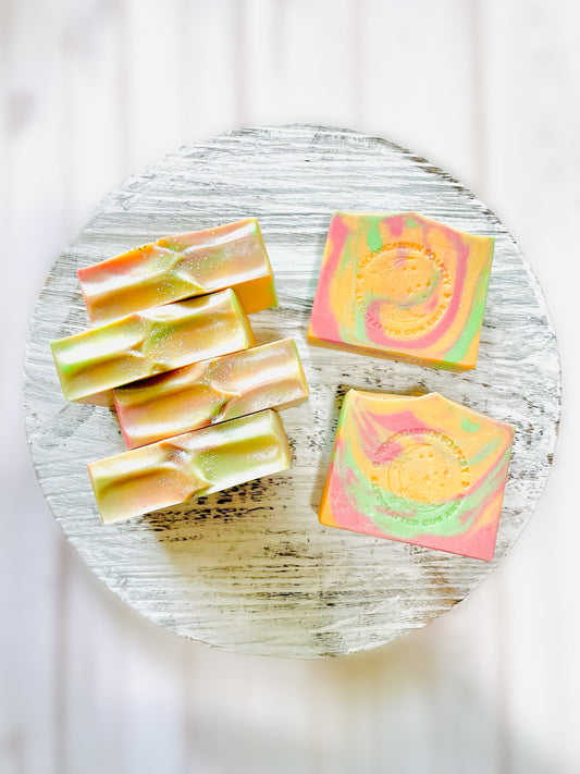 Six bar soaps on top of a round wooden serving tray. 