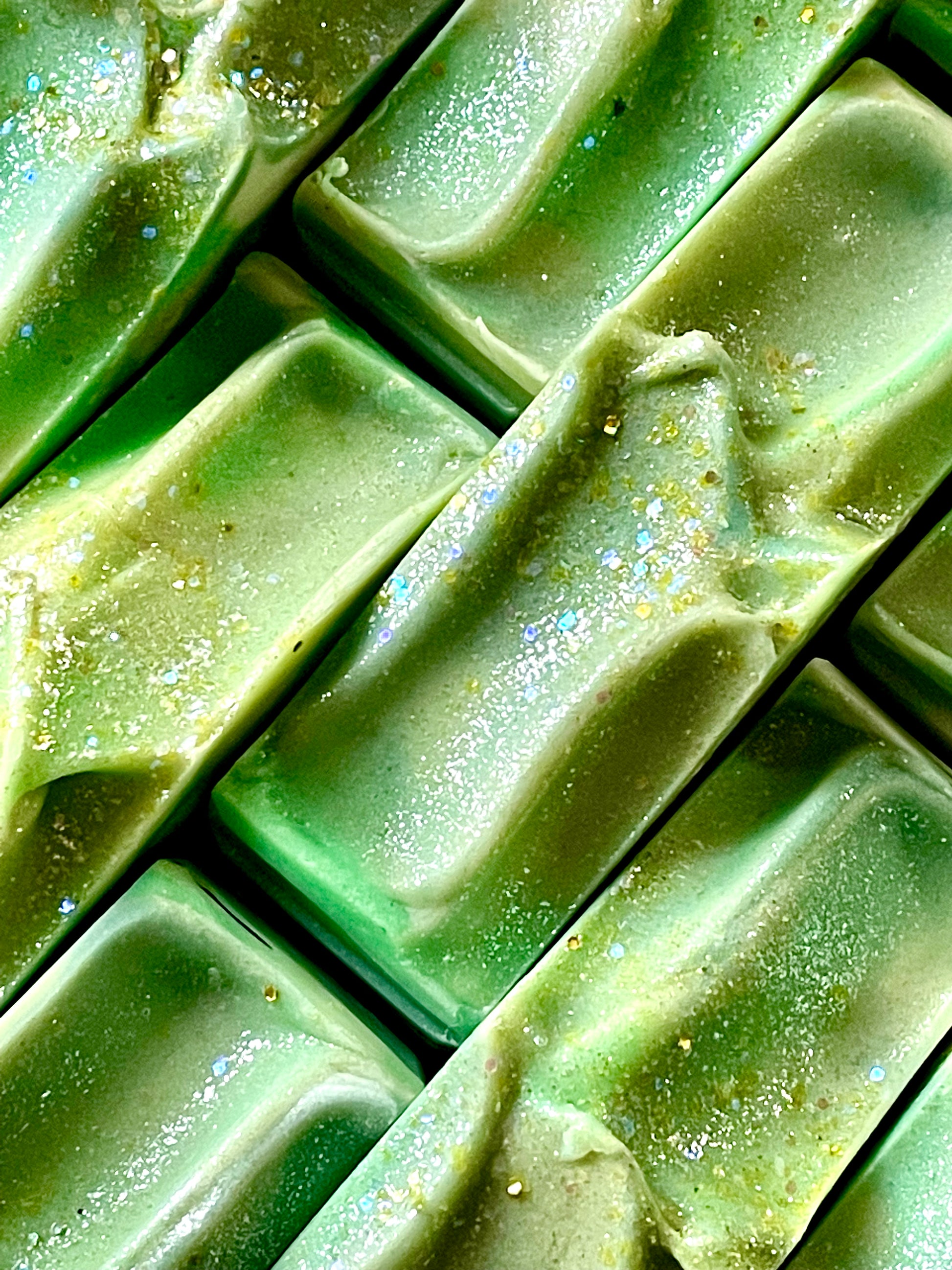 A closeup of the tops of Just Lucky bar soaps. Each bar has glitter on top.